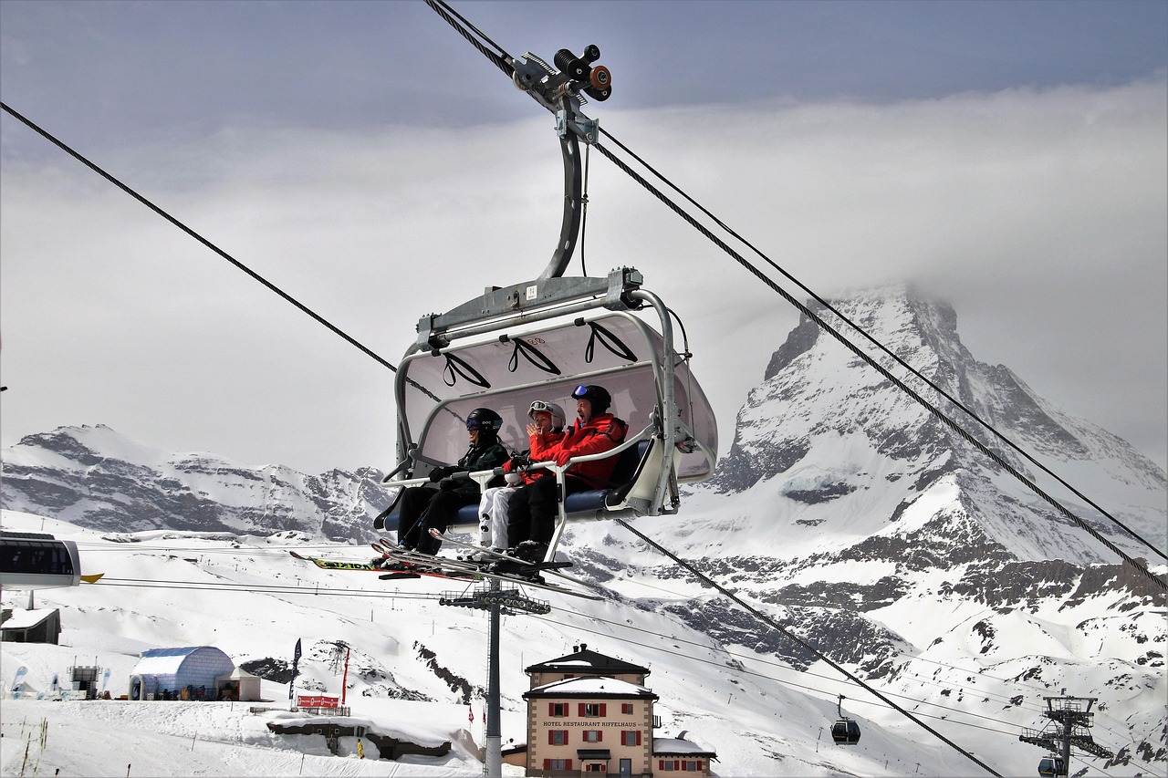 Skiers on a chairlift above the pistes at Zermatt with the Matterhorn behind